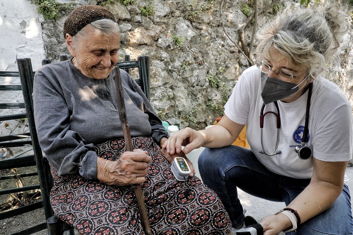 Eine Ärzte der Welt-Mitarbeiterin untersucht eine ältere Patientin. Foto: Yiannis Yiannakopolous