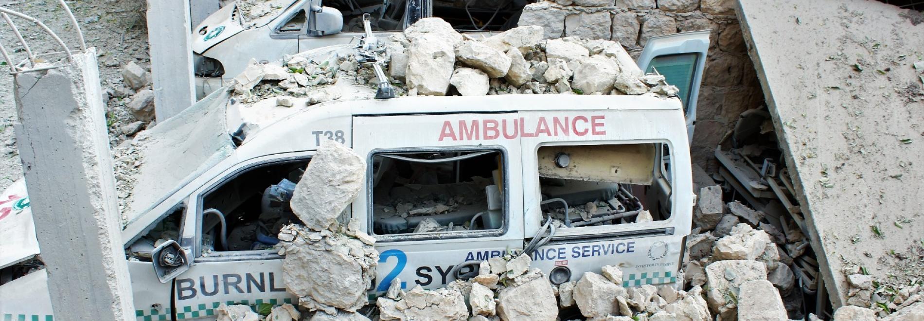 Ein Behandlungsbus unter Trümmern im syrischen Idlib 2016. Foto: Ärzte der Welt