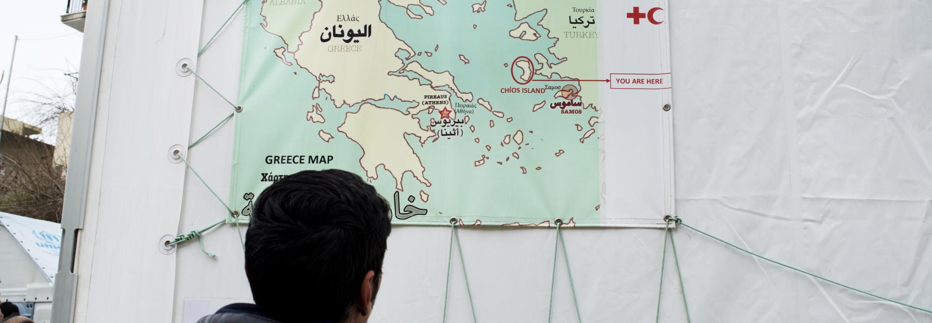 Ein Flüchtling betrachtet eine Karte von Griechenland 