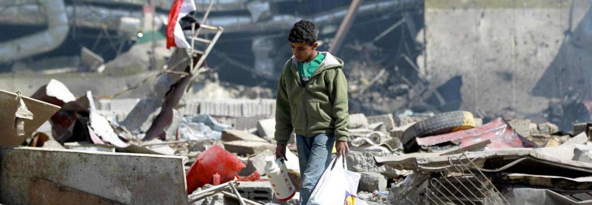 Ein junger Mann läuft über Trümmerfeld im Jemen. Foto: AFP