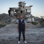 Ein Mitglied des Teams von Ärzte der Welt steht vor einem Gebäude, das bei dem Erdbeben in der Region Hatay in der Türkei zerstört wurde. Foto: Huseyin Aldemir