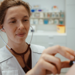 Eine ehrenamtliche Ärztin von Ärzte der Welt untersucht einen Patienten in einer open.med Praxis mit einem Stethoskop. Foto: Max Avdeev