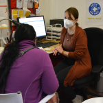 Eine Patientin sitzt in der open.med Praxis in München einer Ärztin gegenüber.
