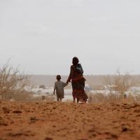 Eine Mutter und ihr Kind auf dem Weg durch eine ausgetrpcknete Landschaft in Äthiopien. Foto: Roberto Schmidt / AFP