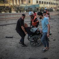 Nachbarn und Rettiungskräfte evakuieren einen alten und behinderten Mann aus dem Gebiet in Gaza-Stadt, das beschossen wurde. Foto: Motaz Azaiza 