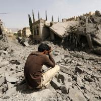 Ein Mann sitzt zwischen Trümmern im Jemen 
