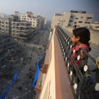 Ein palästinensisches Mädchen beobachtet die Zerstörung eines von israelischen Kampfflugzeugen bombardierten Wohngebäude in Gaza-Stadt. Foto: Mohammed Zaanoun 
