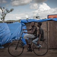 Männer fahren Rad in einem Flüchtlingslager in Mosambik 