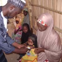 Ein Mitarbeiter von Ärzte der Welt untersucht ein nigerianisches Kind. 