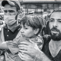 Zwei Männer helfen einem Kind in den Palästinensischen Gebieten. Foto: Mohammed Zaanoun