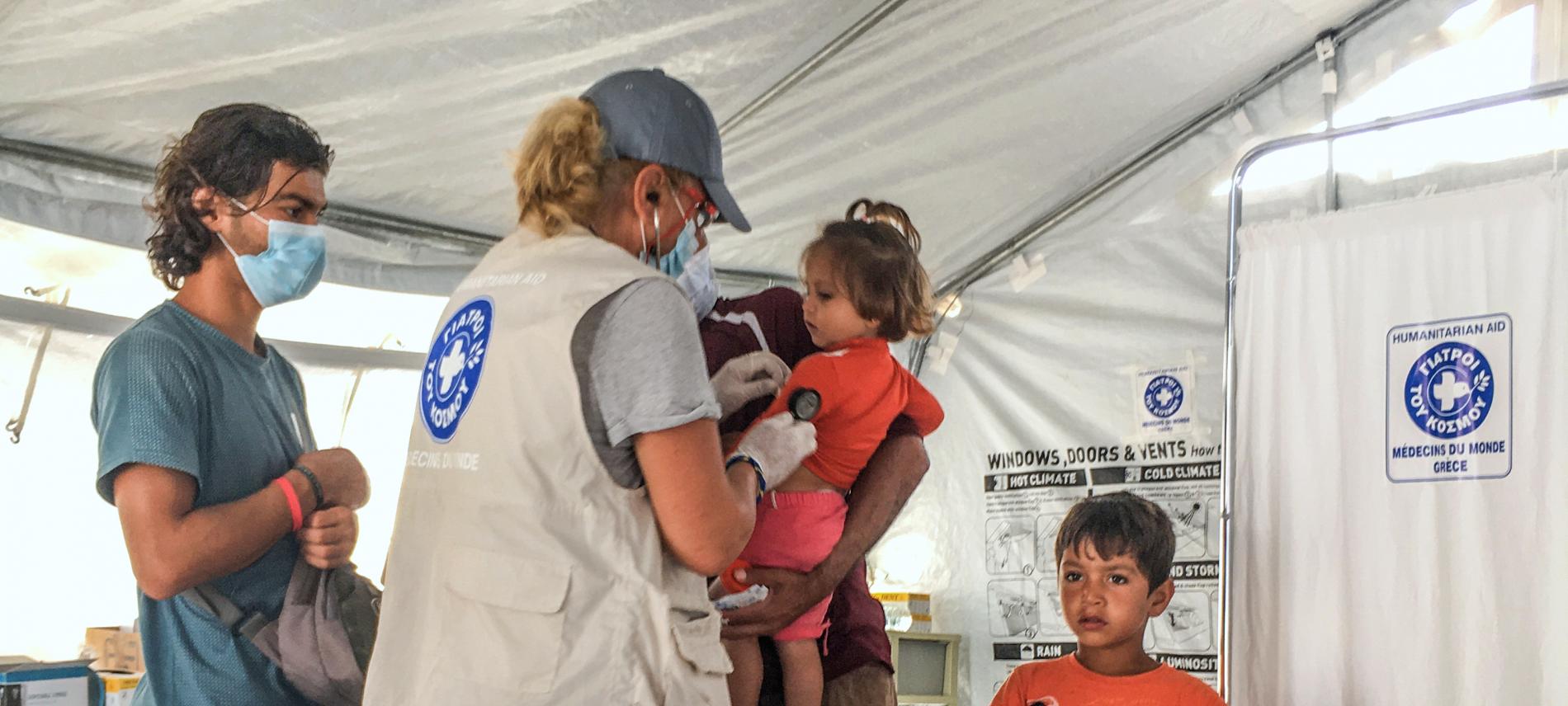 Eine Mitarbeiterin von Ärzte der Welt untersucht ein Kind. Foto: Yiannis Yiannakopoulos