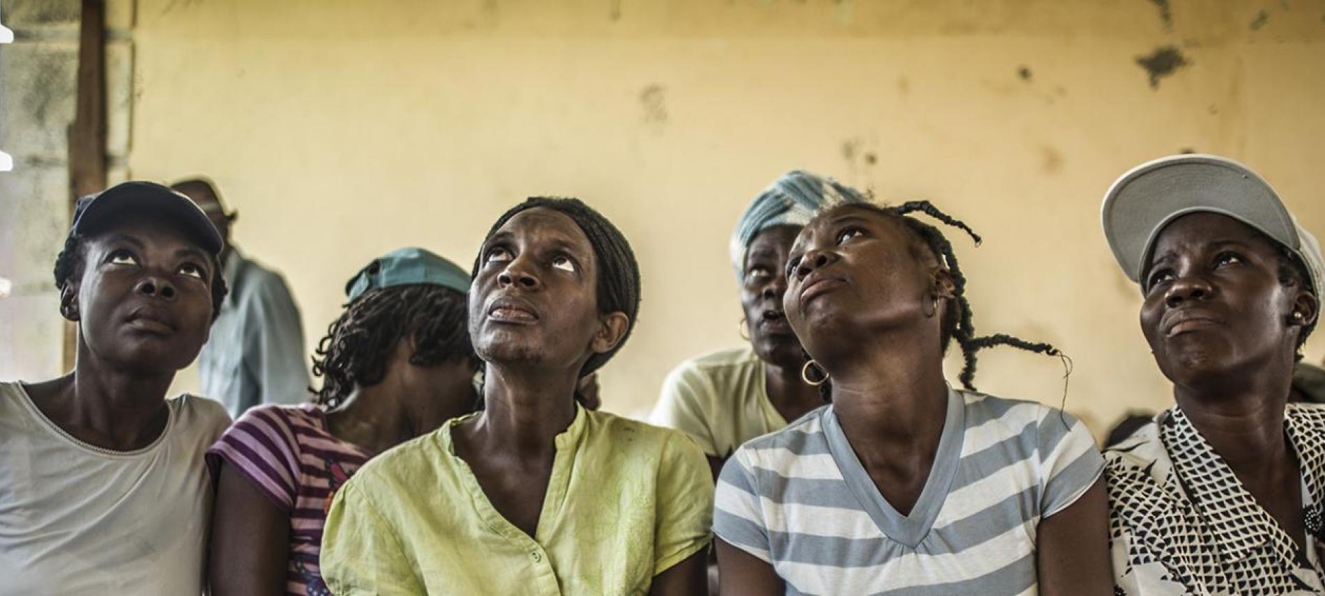 Frauen in Haiti schauen besorgt nach oben