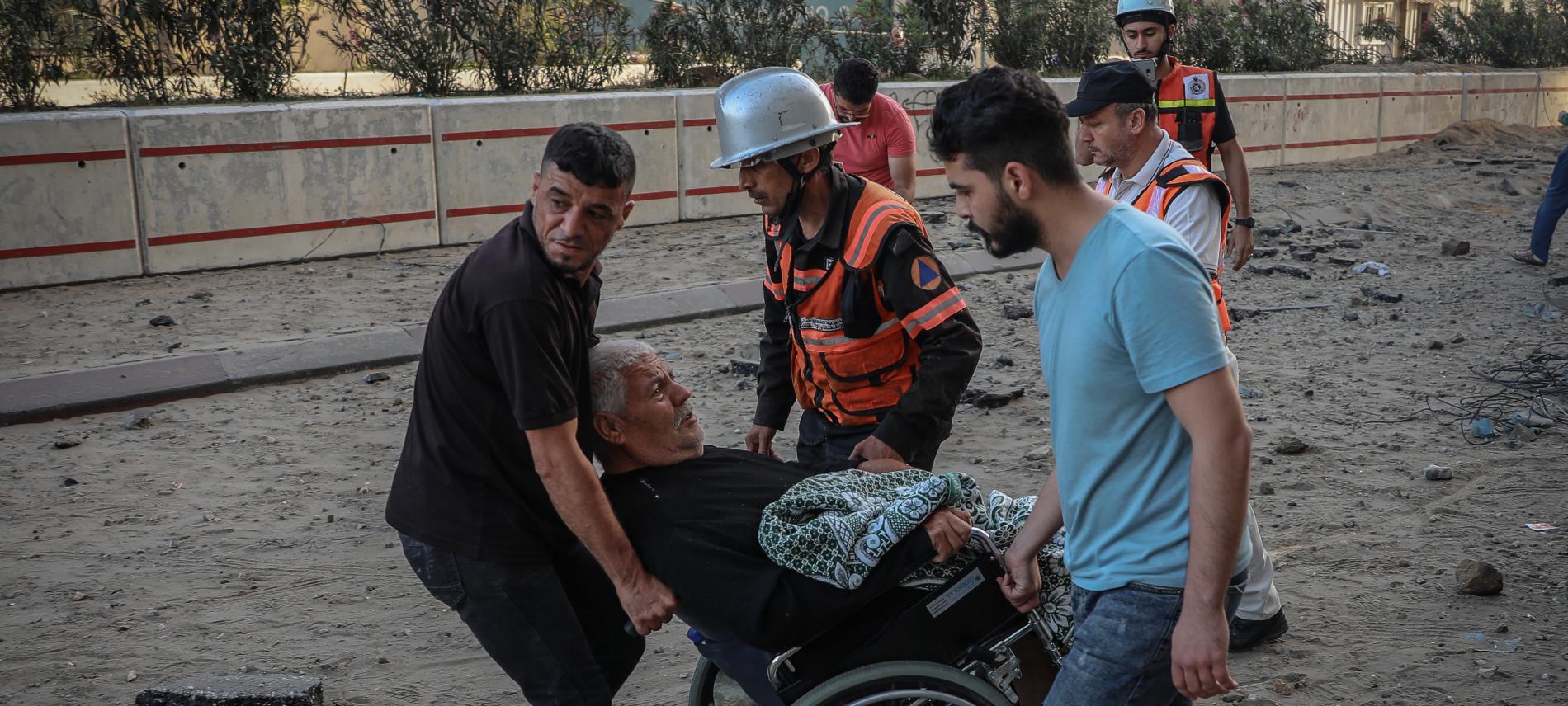 Nachbarn und Rettiungskräfte evakuieren einen alten und behinderten Mann aus dem Gebiet in Gaza-Stadt, das beschossen wurde. Foto: Motaz Azaiza 