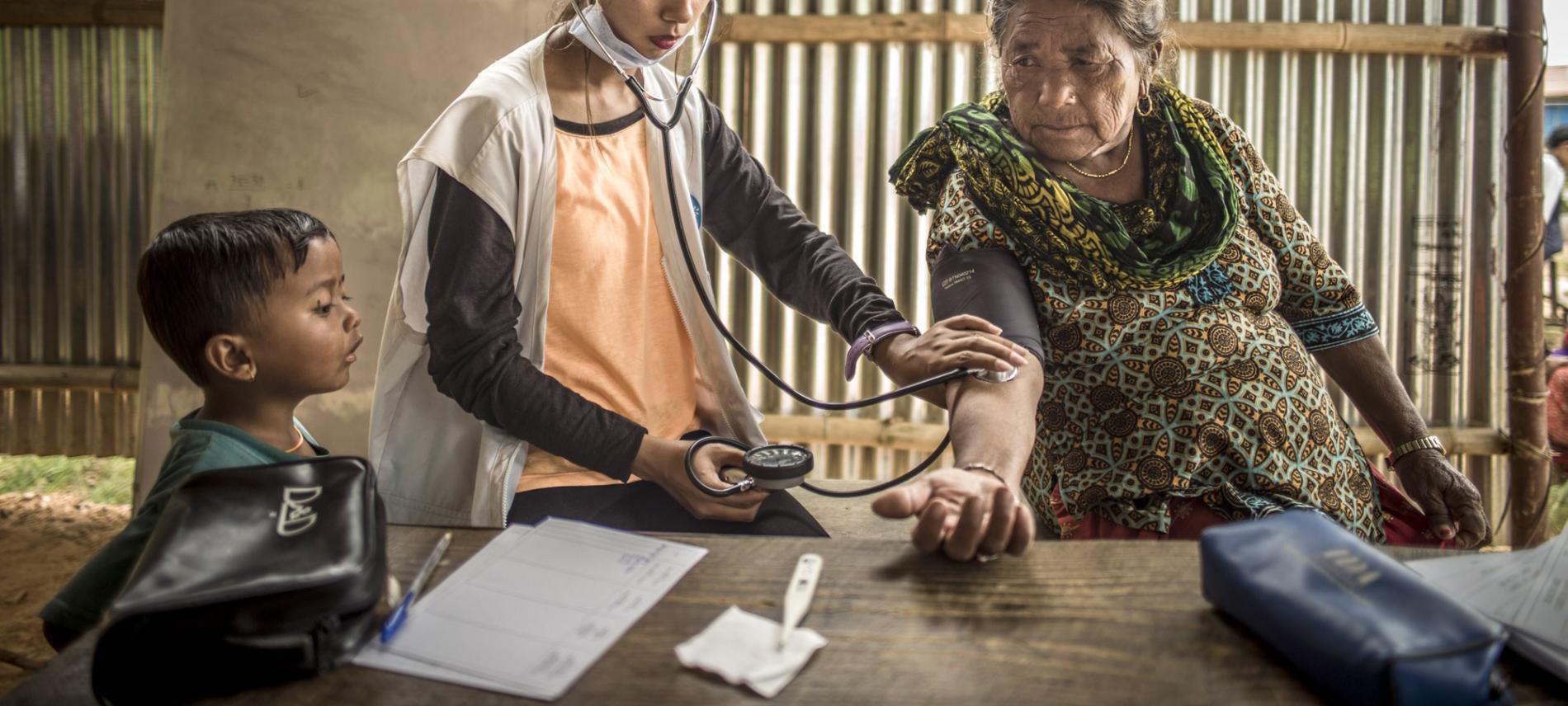 In Nepal misst eine erhrenamtliche Mitarbeiterin den Puls einer Dorfbewohnerin