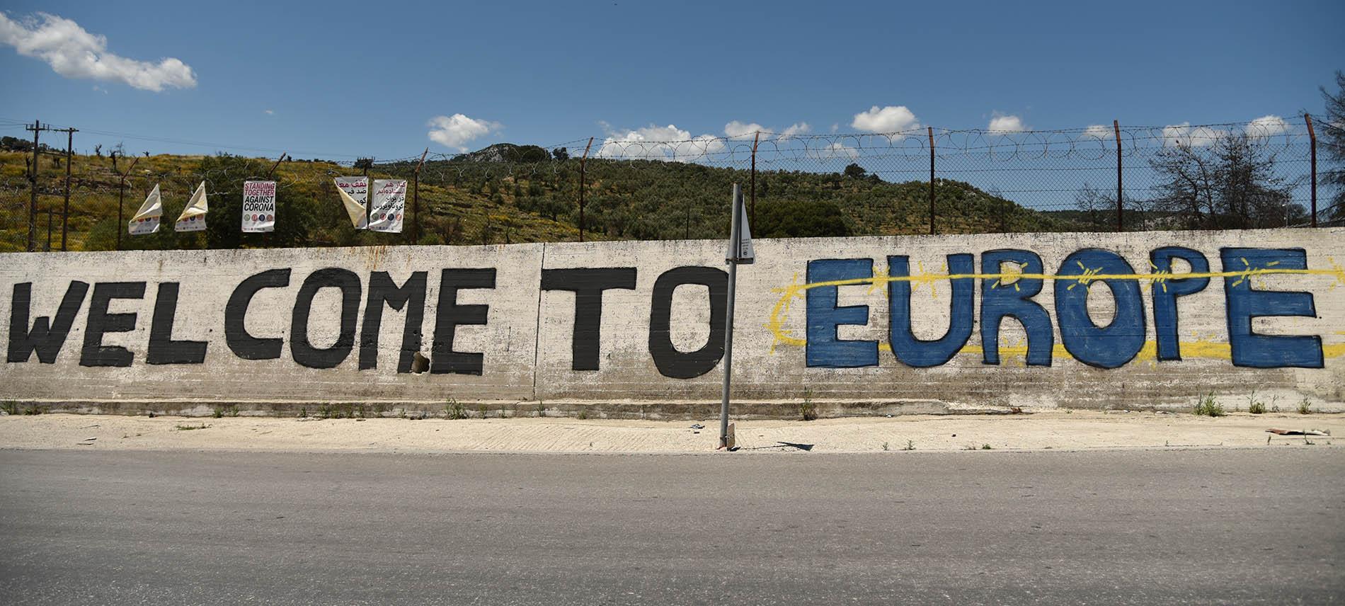 Aufschrift auf einer Mauer um ein Geflüchtetencamp in Griechenland. Foto: Chris Schmid