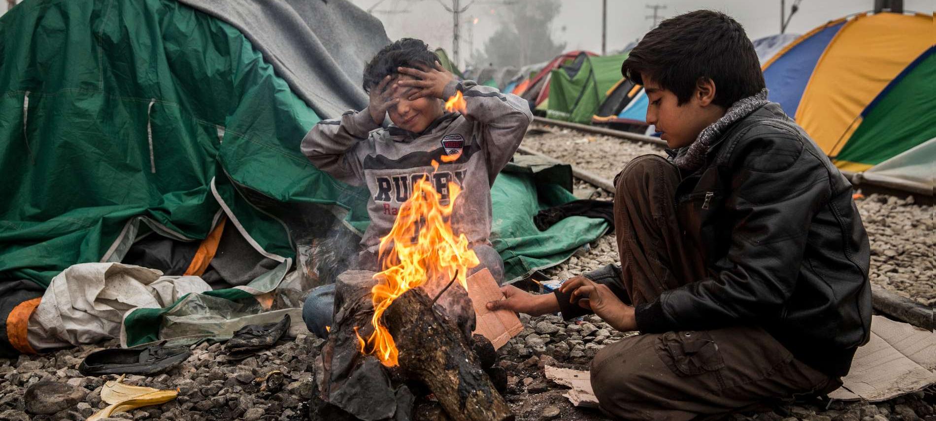 Zwei Kinder wärmen sich im griechischen Flüchtlingscamp Idomeni an einem offenen Feuer. Foto: Olmo Calvo Zwei Kinder wärmen sich im griechischen Flüchtlingscamp Idomeni an einem offenen Feuer. Foto: Olmo Calvo