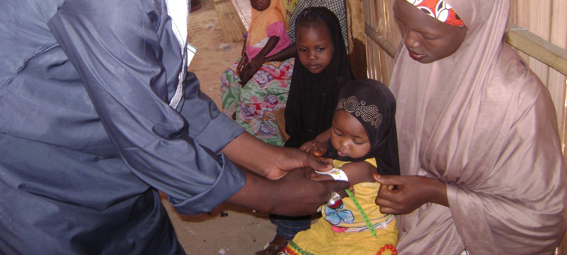 Ein Mitarbeiter von Ärzte der Welt untersucht ein nigerianisches Kind. 