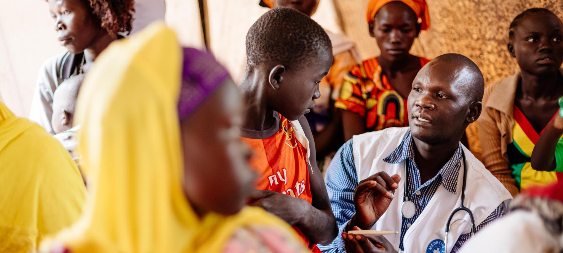 Ein Ärzte der Welt Mitarbeiter behandelt einen Jungen in Uganda, © Sébastien Duijndam
