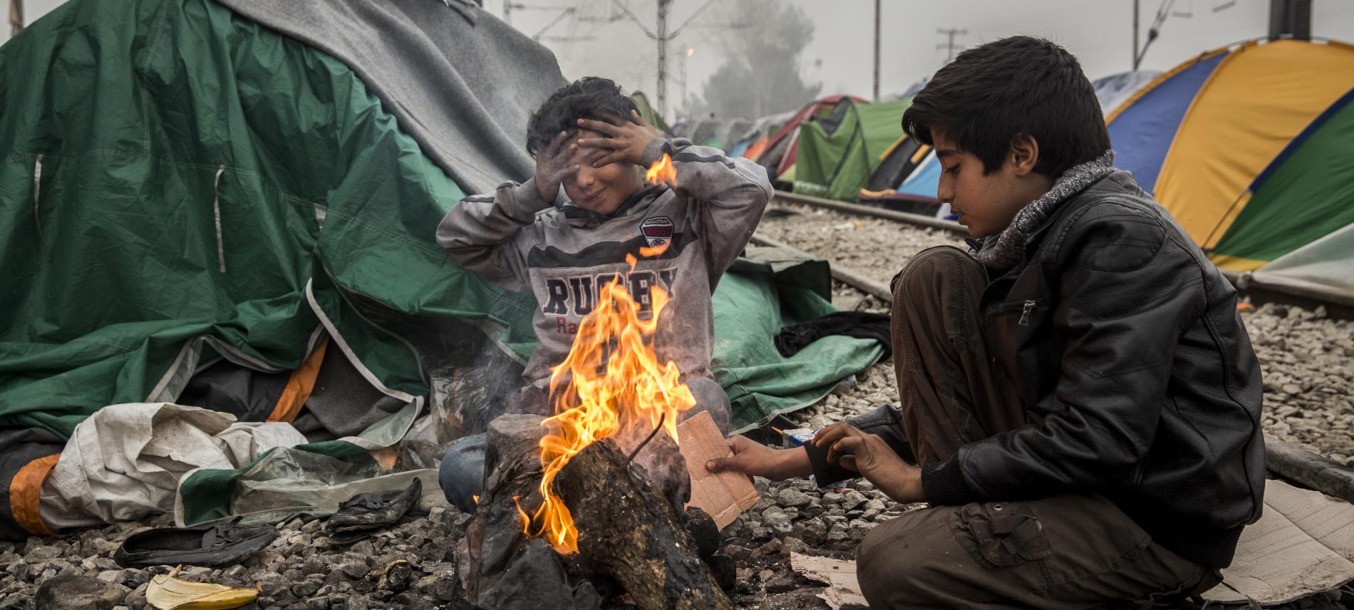 Zwei Kinder wärmen sich im griechischen Flüchtlingscamp Idomeni an einem offenen Feuer. Foto: Olmo Calvo