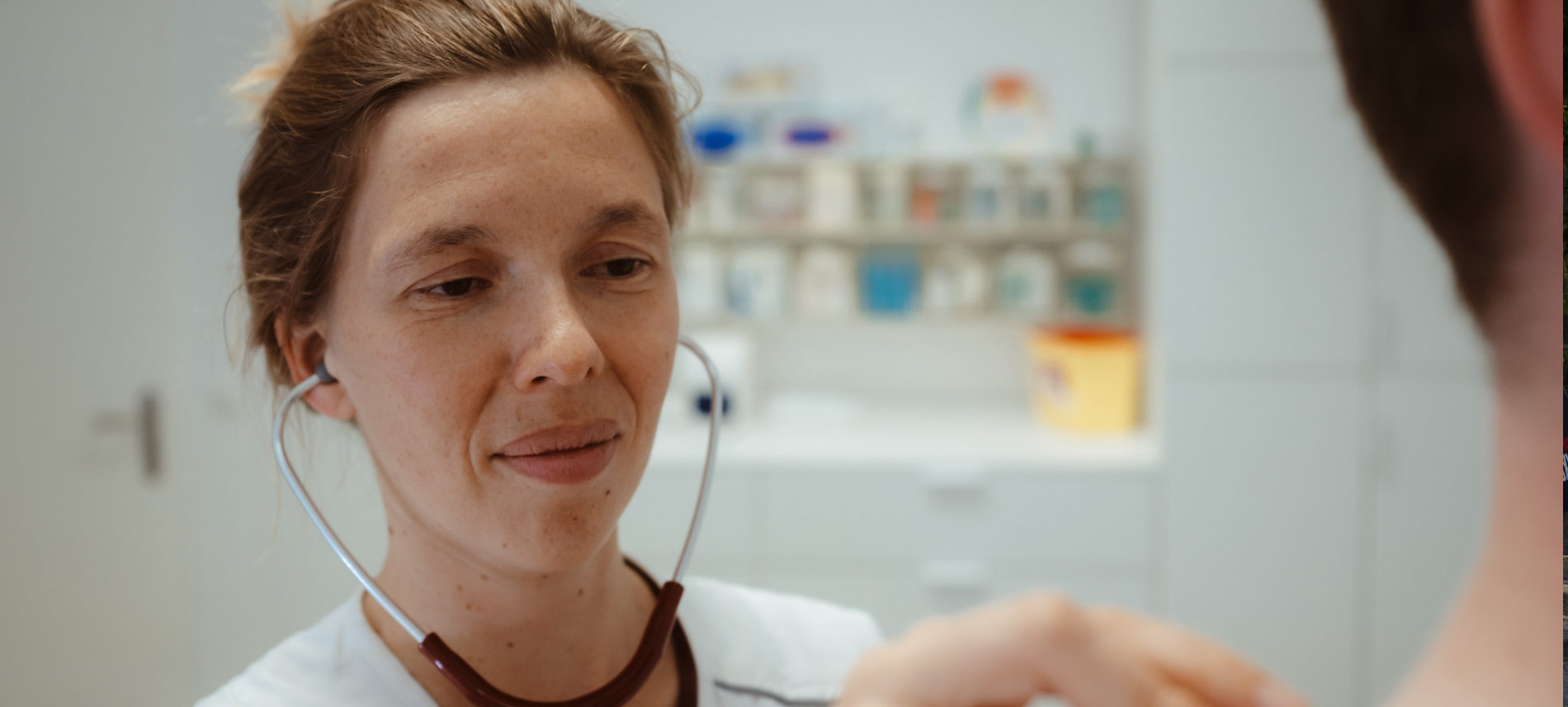 Eine ehrenamtliche Ärztin von Ärzte der Welt untersucht einen Patienten in einer open.med Praxis mit einem Stethoskop. Foto: Max Avdeev