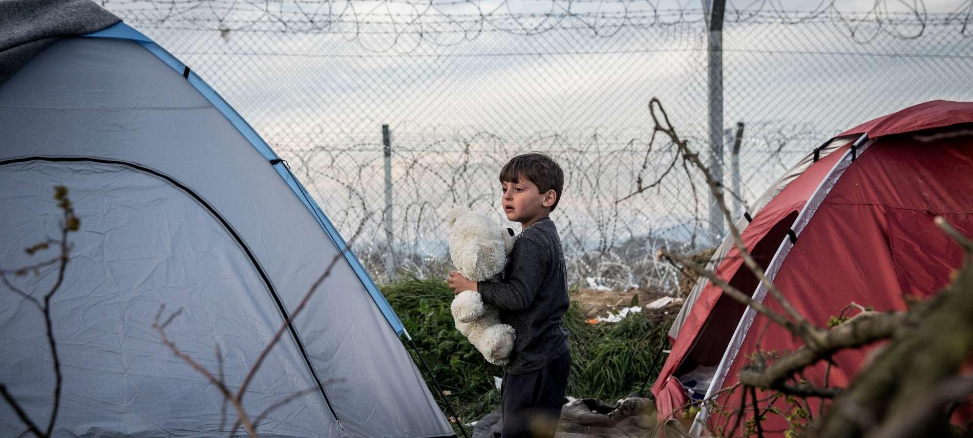 Kind zwischen Zelten am Grenzzaun zwischen Griechenland und Mazedonien (FYROM)