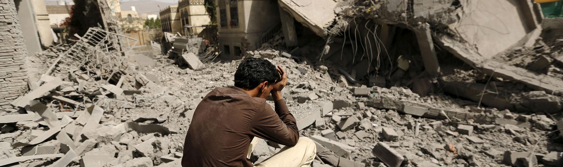 Ein Mann sitzt zwischen Trümmern im Jemen 