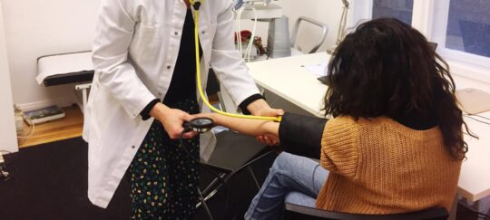 Ärztin behandelt Patientin in medizinischer Anlaufstelle