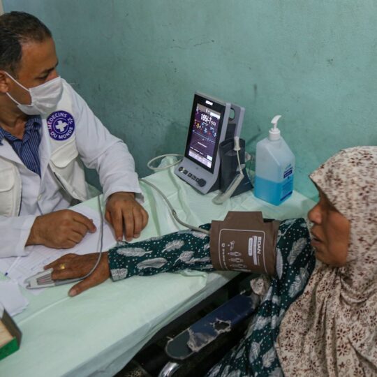 Einer Patientin aus Gaza wird von einem Mitarbeiterin der Blutdruck gemessen.
