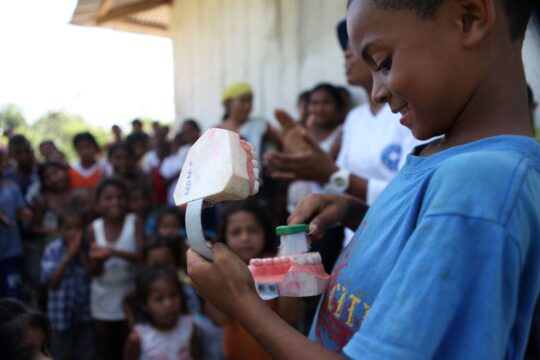 Ein kolumbianischer Junge übt das Zähneputzen an einem Gebissmodell. © Gilbert Poitiers