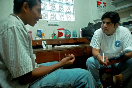 Ein Mitarbeiter von Ärzte der Welt spricht mit einem Patienten in einer medizinischen Unterkunft in Mexiko, die von Ärzte der Welt unterstützt wird. © Ärzte der Welt