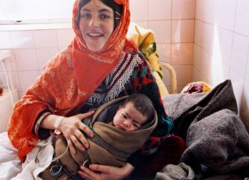 eine Frau in einer Klinik in Afghanistan hält ihr Baby in den Armen.