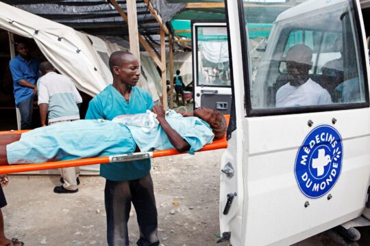Haiti: Ein Mann wird auf einer Liege in ein Fahrzeug von Ärzte der Welt gebracht. © Lahcene Abib