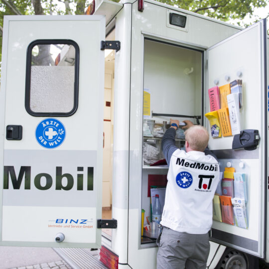 Ein Ehrenamtlicher an einem Schrank mit medizinischen Vorräten in dem MedMobil. © Katharina Meier