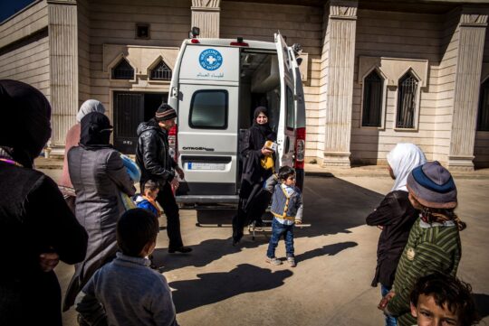 Eine Gruppe von Menschen steht vor der mobilen Klinik von Ärzte der Welt im Libanon. ©Olivier Papegnies