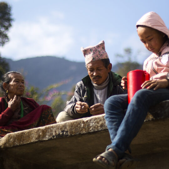 Nepal: Ein Mann, eine Frau und ein Kind sitzen auf einer Mauer. © Ärzte der Welt