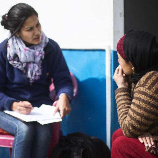 Nepal: Zwei Frauen sitzen vor einer Tür, ins Gespräch vertieft. © Ärzte der Welt