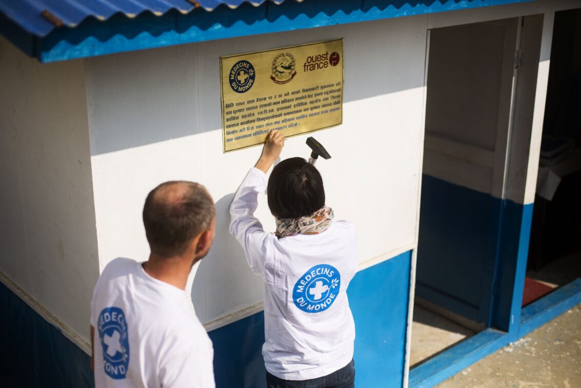 © Ärzte der Welt
Zwei Mitarbeiter von Ärzte der Welt bringen ein Schild an der Hauswand einer Gesundheitseinrichtung in Nepal an. © Ärzte der Welt