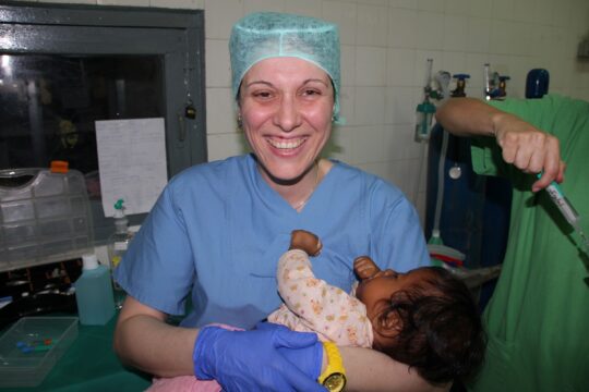 Kambodscha: Kleines Mädchen guckt lächelnd hinter einer Tür hervor. © Ärzte der Welt