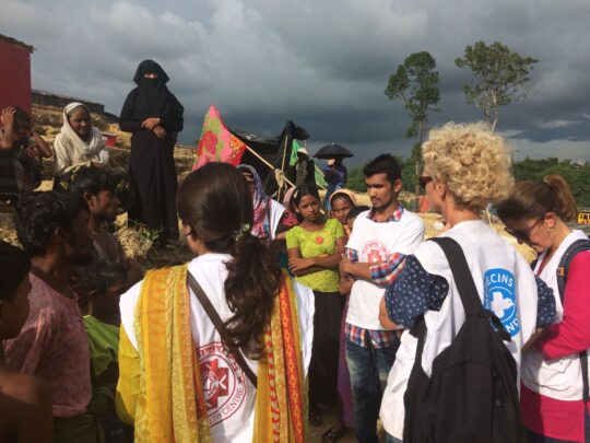 Mitarbeiterinnen von Ärzte der Welt stehen mit mehreren Menschen zusammen in einem Flüchtlingslager in Bangladesch. © Lea Gibert