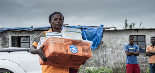 Nachdem Wirbelsturm Ida über Mosambik gefegt war, verteilt eine Mitarbeitende Medikamente. © Czuko Williams