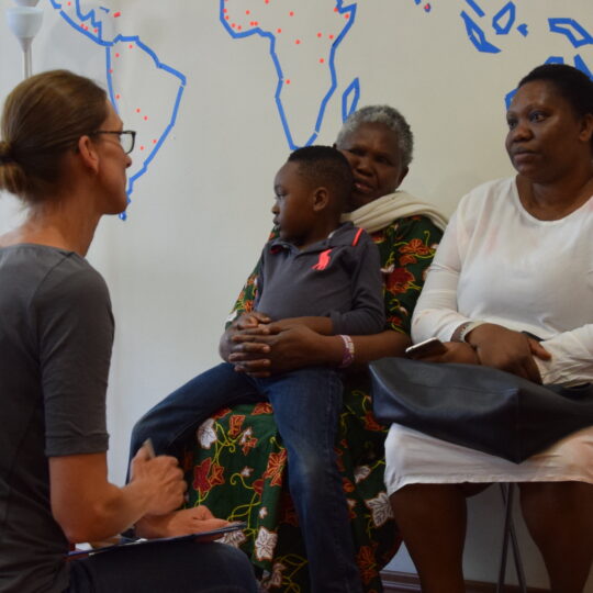 Eine Mitarbeiterin spricht mit zwei Besucherinnen und einem Kind in der Anlaufstelle in München. © Ärzte der Welt