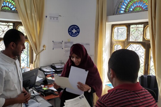 Jemen: Eine Frau blickt auf Unterlagen in einem Büro von Ärzte der Welt -©Wafaa Alsaidy