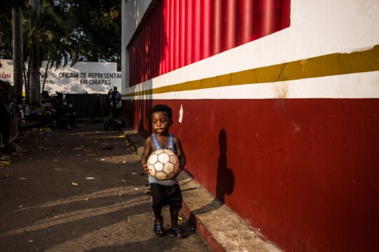 Mexiko: Ein Junge läuft mit einem Fußball in der Hand eine Mauer entlang. © Olivier Papegnies