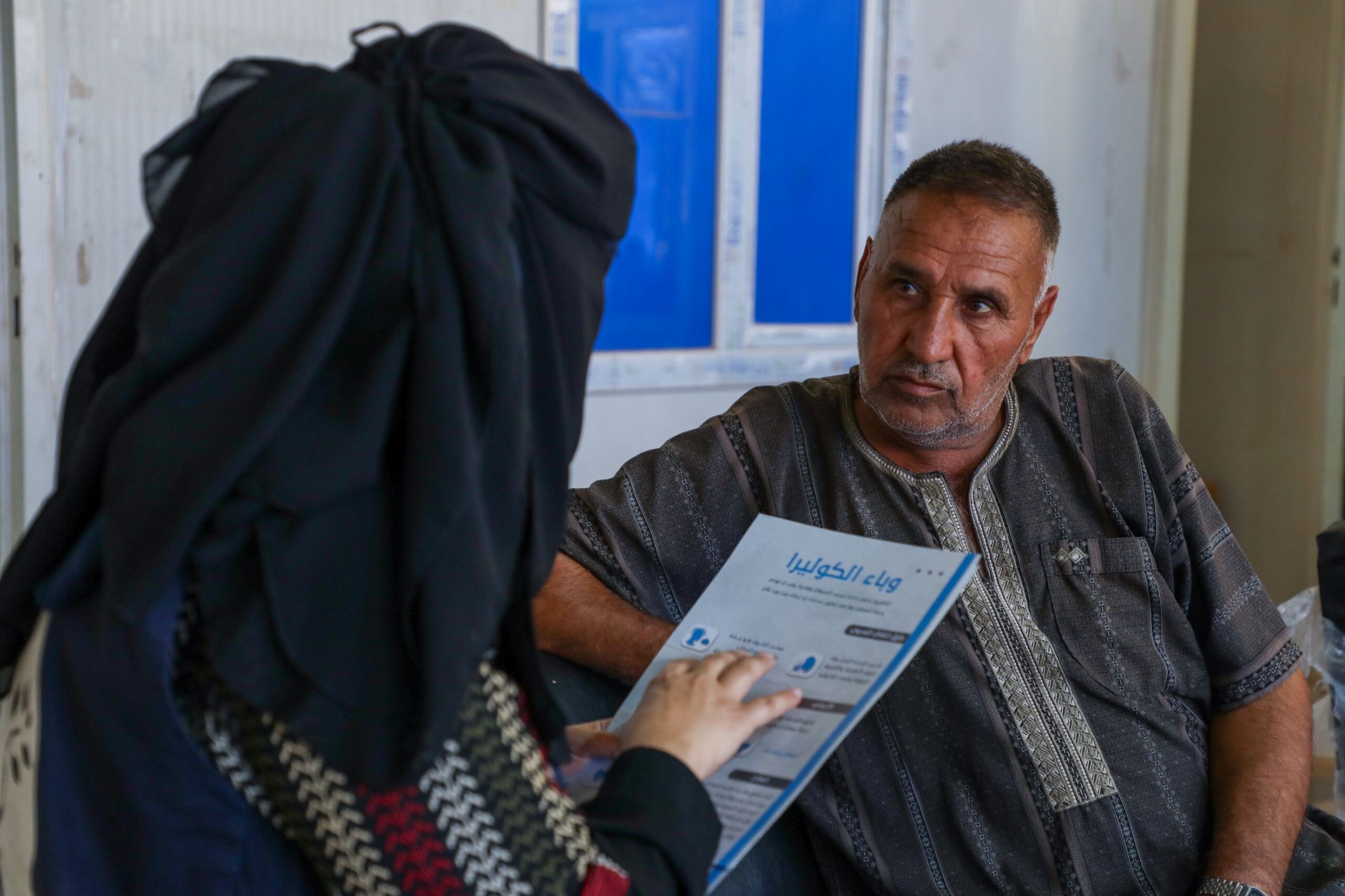 Syrien, Idlib: Eine Mitarbeiterin spricht mit einem Mann, er hört konzentriert zu. Nach dem Erdbeben an der syrisch-türkischen Grenze leistete Ärzte der Welt medizinische und psychologische Nothilfe. © Ärzte der Welt