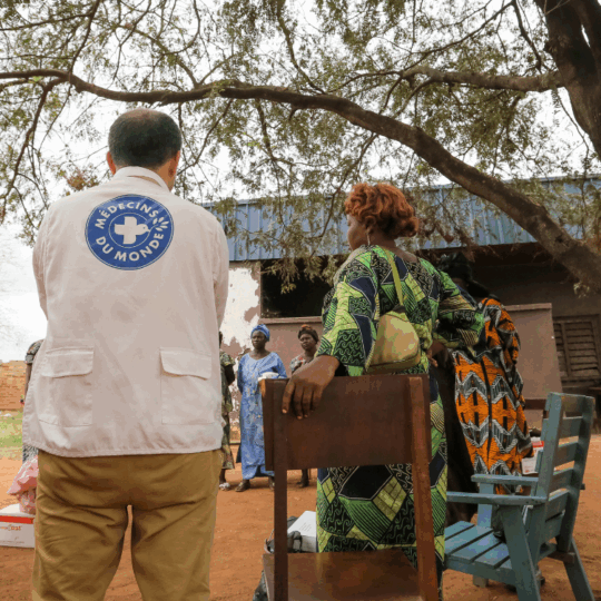 in Helfer von Ärzte der Welt unterhält sich mit einer Gruppe von Einwohnern in der Zentralafrikanischen Republik. © Sebastién Duijndam