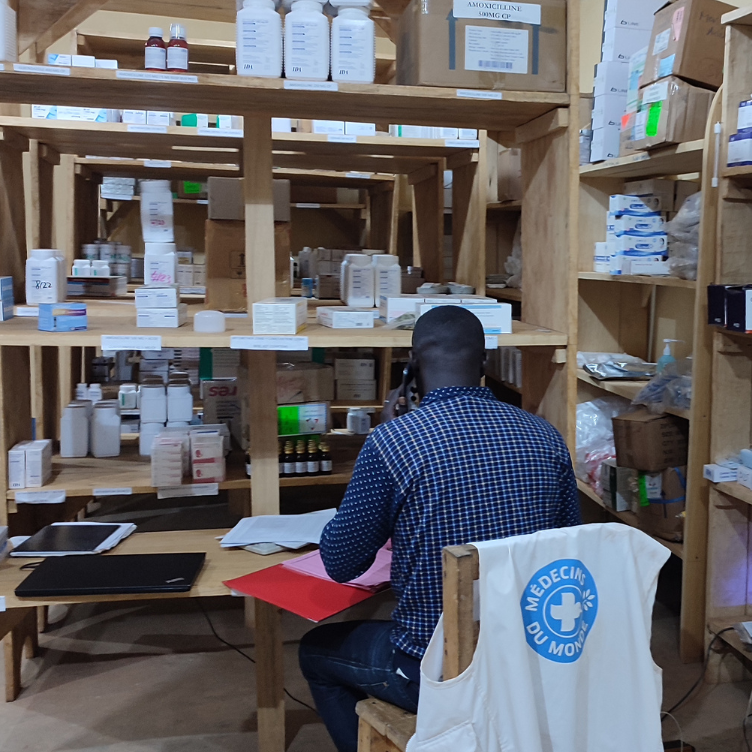 Zentralafrikanische Republik: Ein Helfer von Ärzte der Welt sitzt an einem Tisch. Neben ihm sind Schränke mit Medikamenten. © Ärzte der Welt