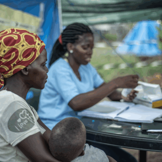 Mosambik: Ein Mitarbeiter von Ärzte der Welt spricht mit einer Mutter, die ihr Kind hält. © Czuko Williams