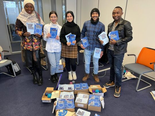 Deutschland: Multiplikator*innen stehen lächelnd nebeneinander und halten ,,Ärzte der Welt” Broschüren in den Händen. © Ärzte der Wel