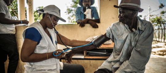 Mitarbeitende von Ärzte der Welt misst den Blutdruck eines Mannes auf Haiti. © Oliver Papegnies