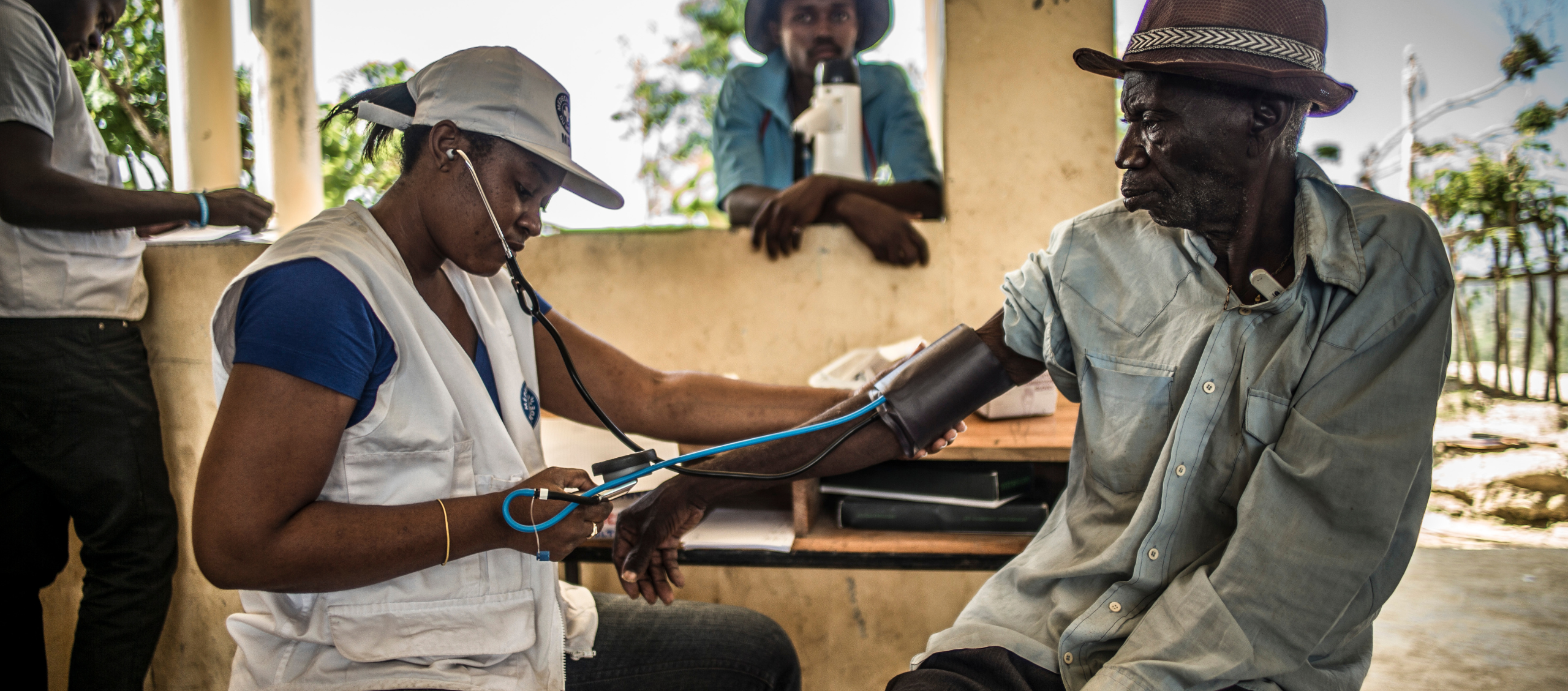 Mitarbeitende von Ärzte der Welt misst den Blutdruck eines Mannes auf Haiti. © Oliver Papegnies